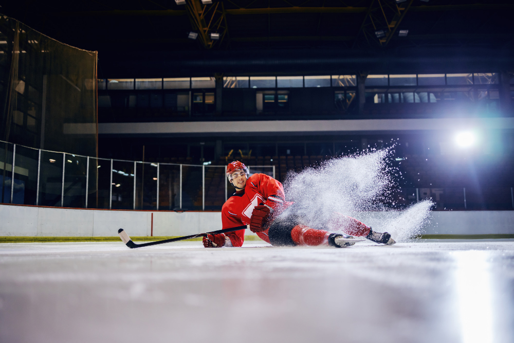 handsome caucasian young hockey player fell down ice during match