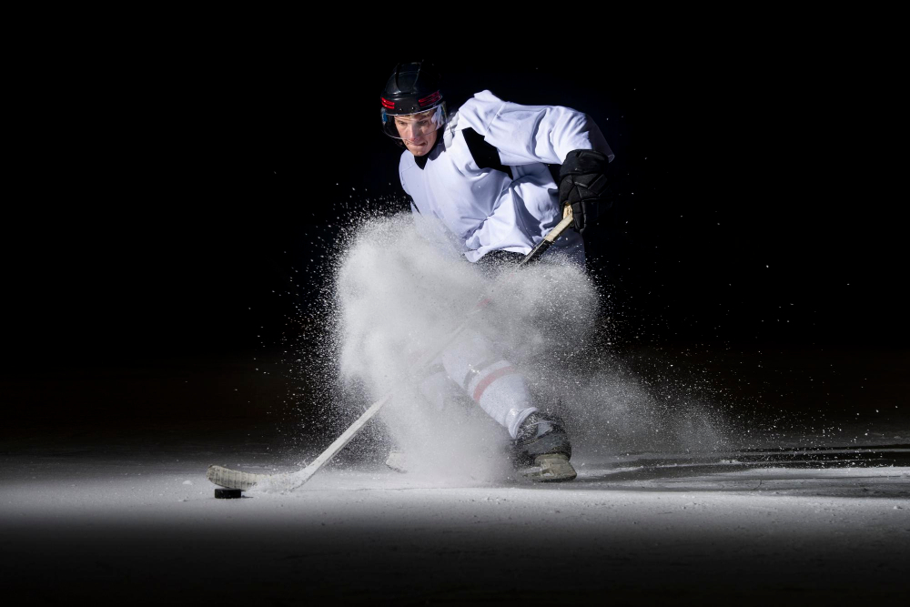 man playing ice hockey against black background